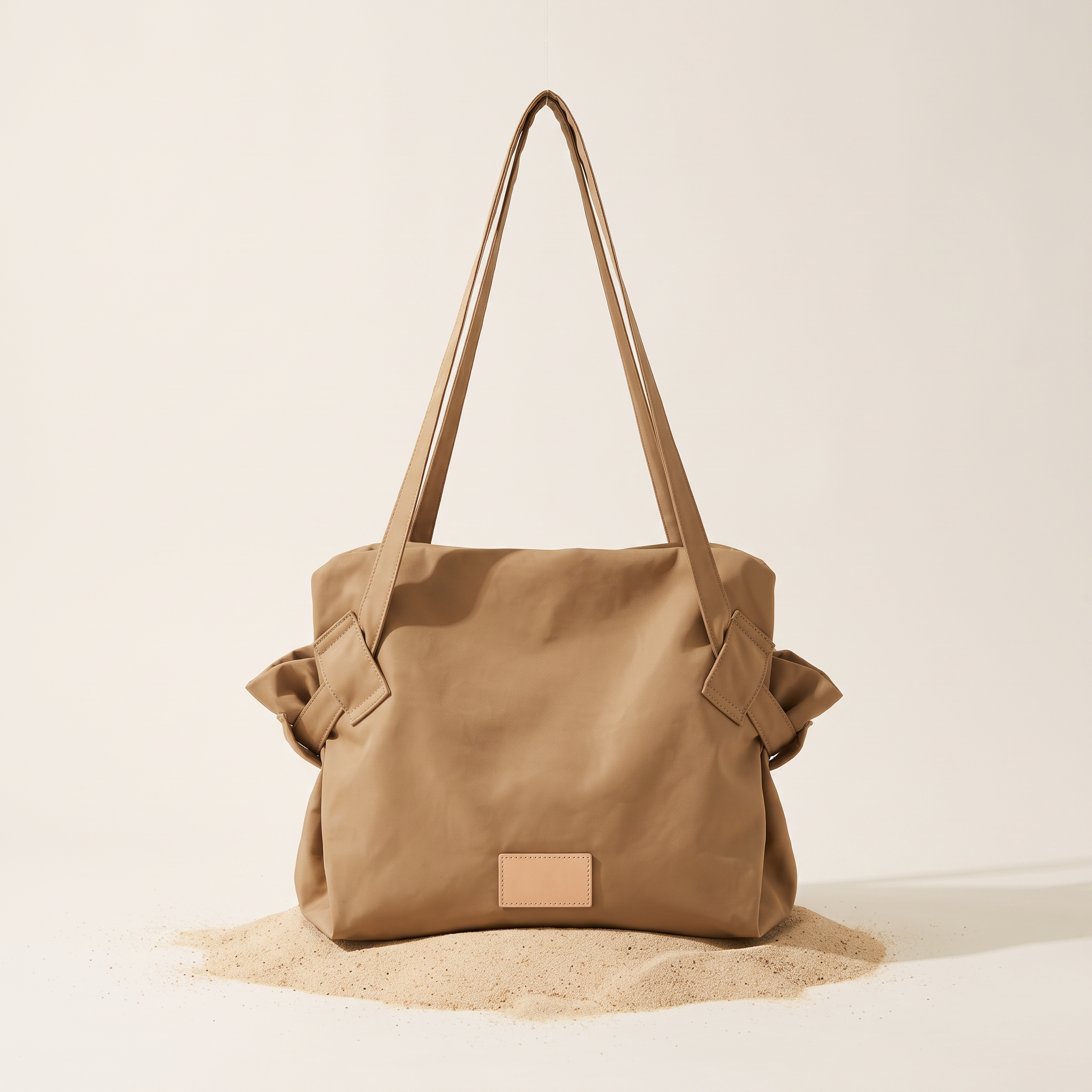 The Pilo Bag in Khaki on sand